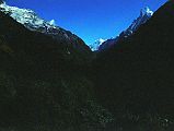 104 Looking Up Modi Khola Valley with Annapurna III and Machapuchare I left Chomrong (2210m) at 6:20 and descended a couple of thousand stone steps to lower Chomrong, crossed the Chomrong Khola (1860m) at 6:50, and then trekked steeply uphill to Sinuwa (2340m), reaching the bottom of the village at 7:25, stopping for a Coke and then leaving the upper part of the village at 8:00. �Next day we entered the gorge proper of the Modi Khola. It was an incredibly impressive place, dense forest of gnarled trees and dead bamboos that looked like skeletons in its bed and lower flanks, huge walls towering on either side. Waterfalls cascaded down and the river in the bed of the gorge set up a restless thunder� (Chris Bonington, Annapurna South Face).
